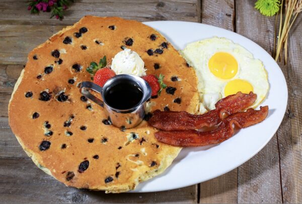 Big O’ Blueberry Pancake with eggs and bacon at Hash House A Go Go Henderson—Must visit location for family-friendly breakfasts and hearty brunch cravings.