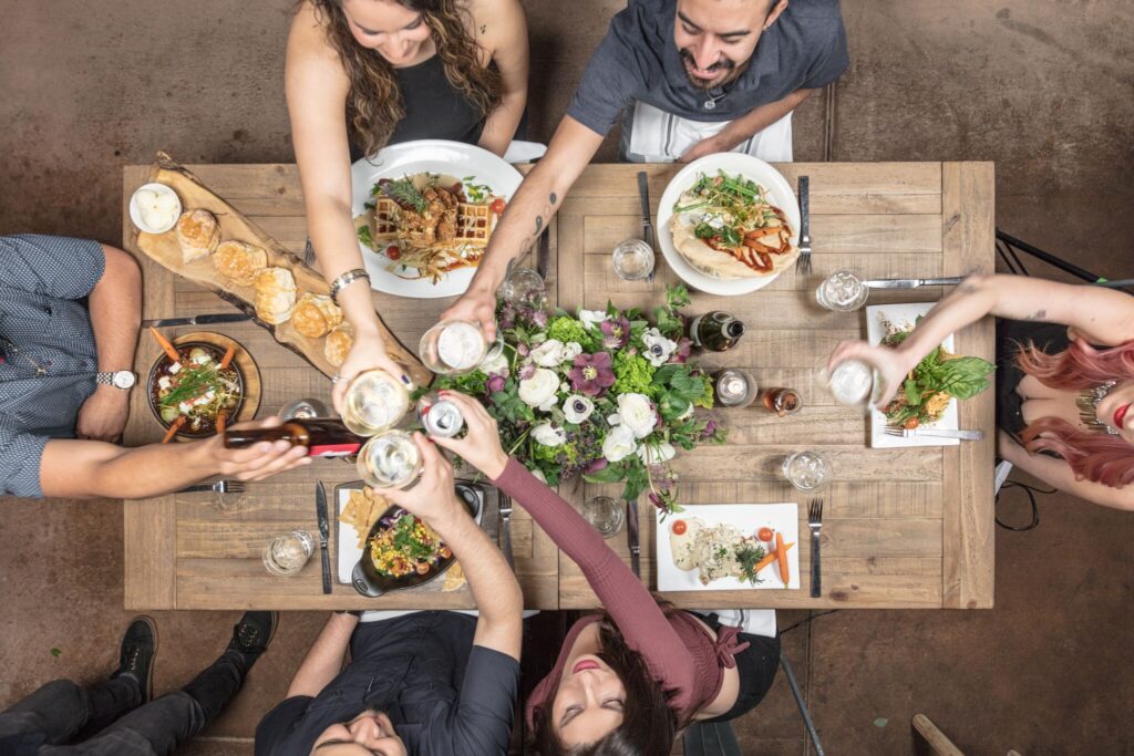 Group dining at Hash House A Go Go Henderson—friends gathered around a rustic table sharing hearty dishes, cocktails, and good conversation.