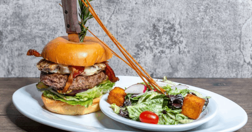 Try this loaded burger with salad at Hash House A Go Go Henderson—stacked high with bacon, cheese, and served with a fresh garden salad.